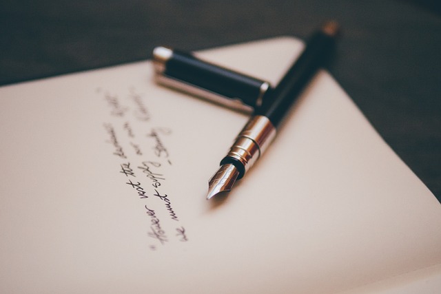An image of an ornate calligraphy pen floating above a blank page, surrounded by a vibrant spectrum of colors